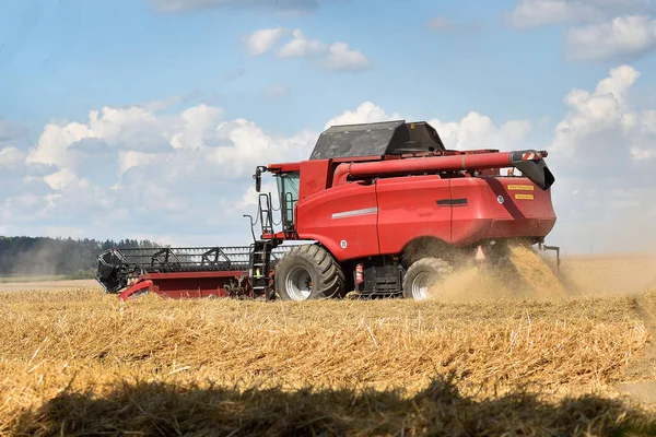 Una Cosechadora Roja Corta Campo Grano Día Caluroso Soleado Ondulaciones —  Fotos de Stock