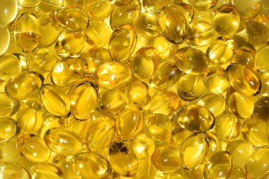 Bir sürü sarı kapsül, altın yağlı balık omega 3 kapsülü... Omega-3 yağ damlaları beyaz arka bölmede. Balık yağı.