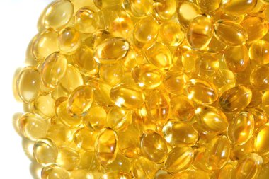 Bir sürü sarı kapsül, altın yağlı balık omega 3 kapsülü... Omega-3 yağ damlaları beyaz arka bölmede. Balık yağı.