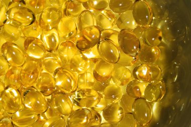 Bir sürü sarı kapsül, altın yağlı balık omega 3 kapsülü... Omega-3 yağ damlaları beyaz arka bölmede. Balık yağı.