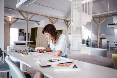  Sanatçı stüdyoda bir resim çizin. Resimde watecolor tarafından. İş günü. İş yerinde bir kadın 