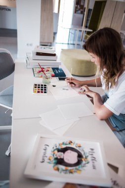  Sanatçı stüdyoda bir resim çizin. Resimde watecolor tarafından. İş günü. İş yerinde bir kadın 