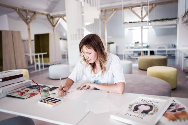  Sanatçı stüdyoda bir resim çizin. Güzel kız boya beyaz iç