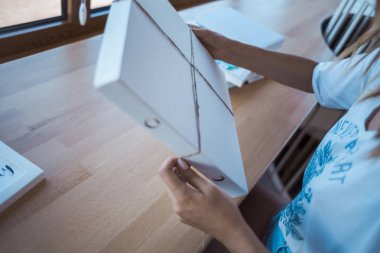 Genç kadın işini kutusunda ambalaj. Hediye fikri. Resimde Victoria Rusyn tarafından. Kırmızı kurdele kutusu