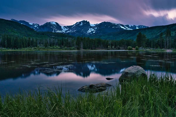 Colorado 'daki Sprague Gölü. Rocky Dağı Ulusal Parkı 'nda gün batımına uzun süre maruz kaldık. Colorado kayaları uzaklardan görülebiliyor. Ateşli bulutlarla dolu renkli gün batımı
