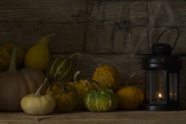 Bir fener ve bir mum ile dekoratif kabaklar soyut görünümünü ahşap arka plan üzerinde. Cadılar Bayramı. Üstten görünüm.