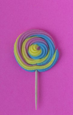 Pembe Kağıt arka plan üzerinde renkli, el yapımı girdap lolipop yaz renkleri yaratıcı görünümü. Minimalizm. Soyutlama. Yaratıcılık. Üstten görünüm.