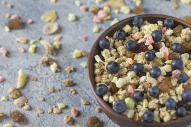 Kuruyemiş düzensiz arka planı gri günü kahvaltıda bir seramik plaka ile müsli.