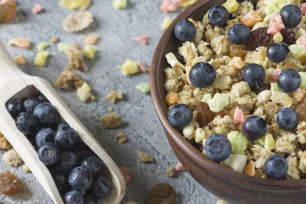 Kuruyemiş düzensiz arka planı gri günü kahvaltıda bir seramik plaka ile müsli.