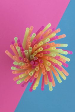 Bir iki tonlu arka plan üzerinde - pembe ve mavi straws(neon colors) parti içme yaratıcı görünümü. Üstten görünüm. 