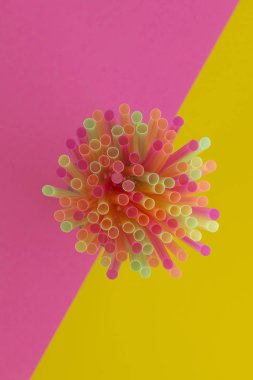 Bir iki tonlu arka plan üzerinde - pembe ve sarı straws(neon colors) parti içme yaratıcı görünümü. Üstten görünüm. 