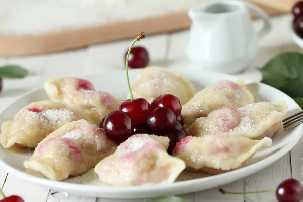 Beyaz ahşap zemin - Ukrayna ulusal çanak üzerinde kiraz ile vareniki (pierogi)