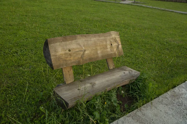 木製のベンチの横からの緑の背景写真 — ストック写真