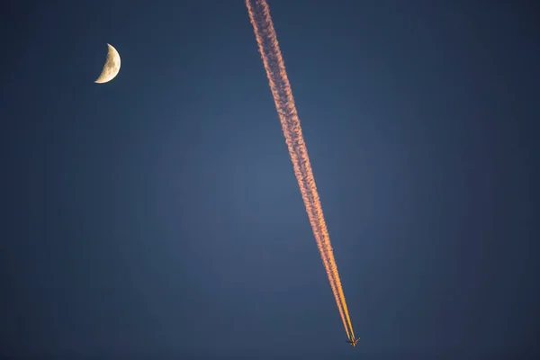 Sunset, moon and airplane in winter in Girona, Catalonia, Spain.