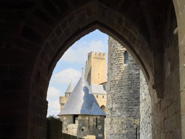 Fransa 'nın ortaçağ şehri Carcassonne' a bakın. Mavi gökyüzünün altındaki kuleleri, duvarları ve kemerleri gösteriyor.