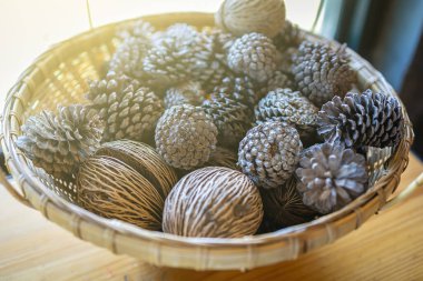 Kurumuş çam kozalakları pencerenin kenarına güneş ışığı konmuş bir septte..