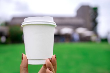 Bulanık kahve dükkanının arka planında beyaz renkli sıcak kahve fincanı. Logo ve metin koymak için kopyalama alanı ile.