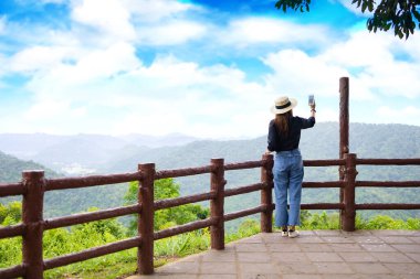 Siyah tişörtlü kadınlar akıllı telefonlarıyla atlı kulüpte fotoğraf çekiyorlar..