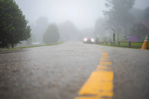 Wet road with car and fog in the morning after rain. Selective Focus.