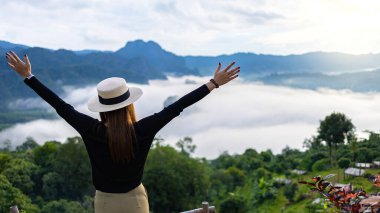 Asyalı kadın ellerini kaldırarak zirveye ulaşıyor. Mutlu kutlamalar, başarılı kadın..