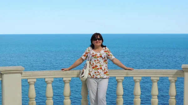  Deniz arka plan üzerinde korkuluk, bir yaz tatili Partenit Kırım'denizde duran kadın.