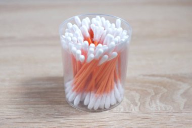 Masadaki konteynırda pamuklu çubuklar var..