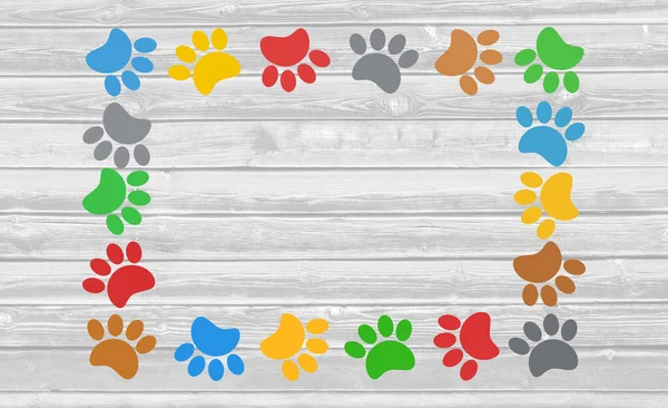 Colorful paw prints animal frame on wooden background with copy space for text.