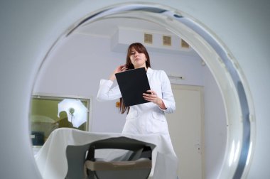 Genç bayan radyologlar tomografi odasında kalıyorlar. Klinikte çalışıyorum. Güzel doktor röntgen, röntgen, tomografi ve MRI 'ya bakıyor. Üniformalı doktor.