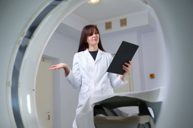 Genç bayan radyologlar tomografi odasında kalıyorlar. Klinikte çalışıyorum. Güzel doktor röntgen, röntgen, tomografi ve MRI 'ya bakıyor. Üniformalı doktor.