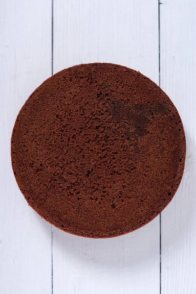 Hafif ahşap arka planda yuvarlak çikolatalı kek.