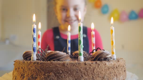 L'enfant souffle les bougies sur le gâteau. — Video