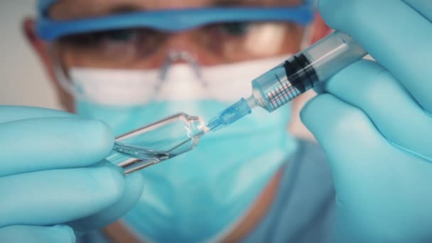 Lékař natáhne lék do injekční stříkačky z ampulky — Stock video