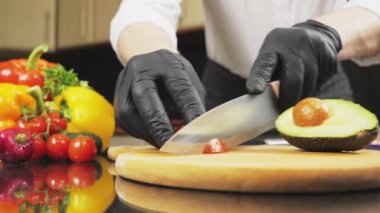 Şef avokado salatası pişirmek için sebze dilimliyor.