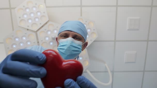 Cirurgião dá um coração a um paciente deitado na mesa de cirurgia — Vídeo de Stock