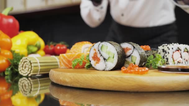 Μαγειρέψτε τα χέρια κάνοντας ιαπωνικό ρολό σούσι με μπαμπού ματ. — Αρχείο Βίντεο