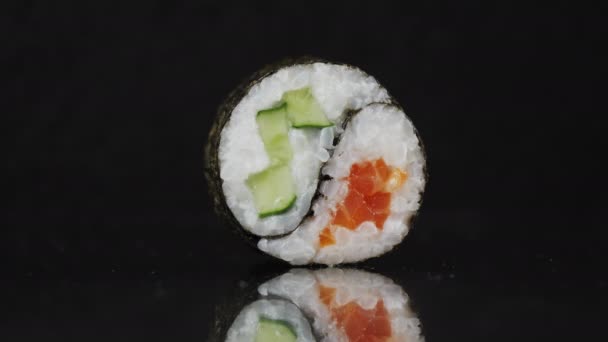 Sushi roll Yin Yang i närbild på en svart bakgrund — Stockvideo