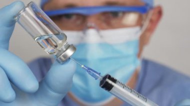 Doktor bir hastaya iğne hazırlar..