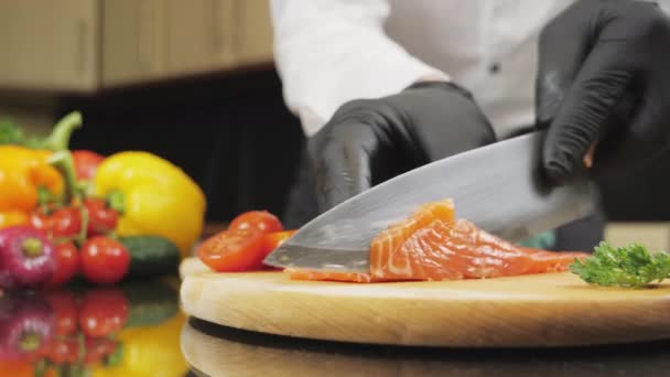 Chef cuts fresh salmon fillet on glass table — Stock Video