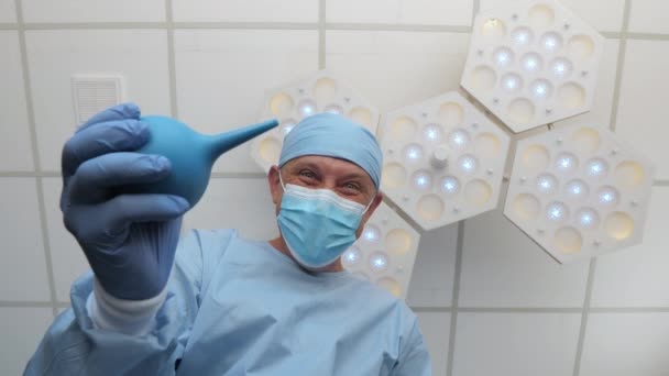 A doctor with an enema in his hands stands above the patient. — Stock Video