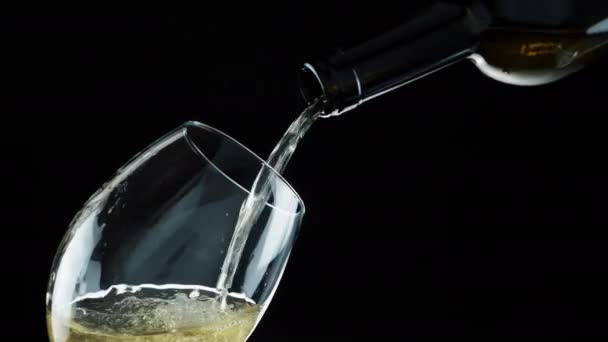 Wylewanie wina z butelki. Białe wino w szklance — Wideo stockowe