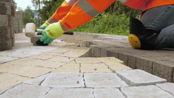 Trabajador de la construcción hace nuevo pavimento de acera con ladrillos de piedra — Vídeos de Stock