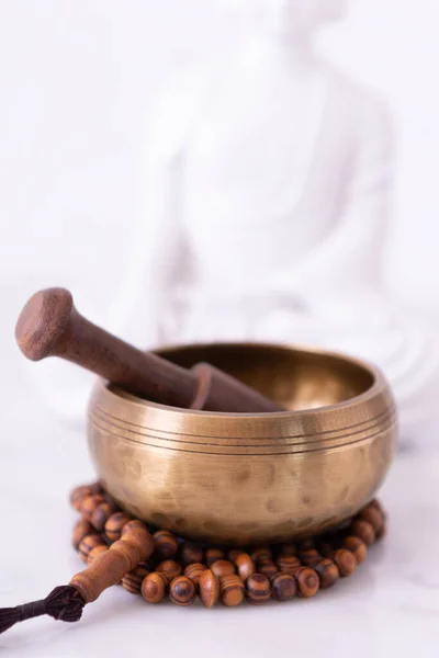 Tibetan bowl, tibetan rosary and buddha with a white background