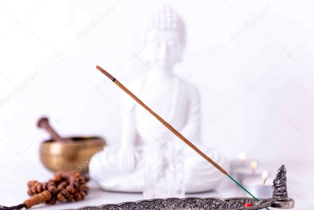 Meditation space with incense, Buddha, clear quartz, candles, tibetan bowl and mala