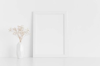 Beyaz çerçeveli bir vazo içinde beyaz bir tablo. Portre oryantasyonu..