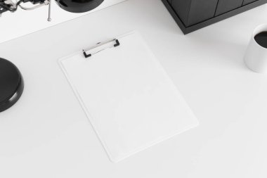 Beyaz bir masadaki beyaz pano çalışma alanı aksesuarları.