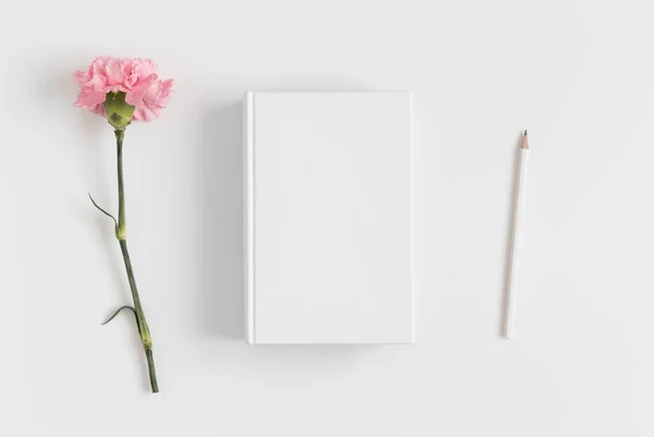 Beyaz Bir Masanın Üzerinde Pembe Karanfil Olan Bir Kitap Modeli — Stok fotoğraf
