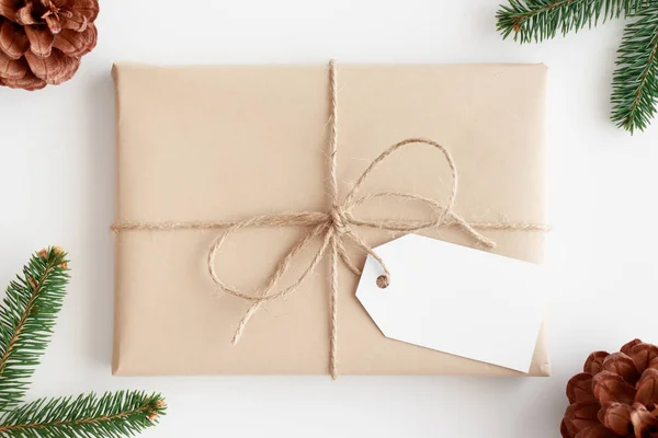 Vista Superior Presente Natal Kraft Com Uma Etiqueta Branco Cercada — Fotografia de Stock