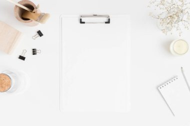 Üzerinde vazo ve çalışma alanı aksesuarları olan beyaz bir pano modelinin üst görüntüsü.