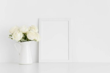 Beyaz çerçeveli bir vazoda bir buket beyaz gül ve beyaz bir masa. Portre oryantasyonu..