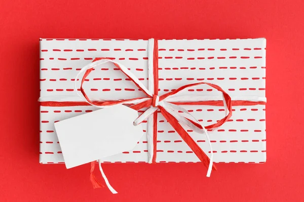 Wit Kerstcadeau Met Een Blanco Tag Mockup Een Rode Achtergrond — Stockfoto